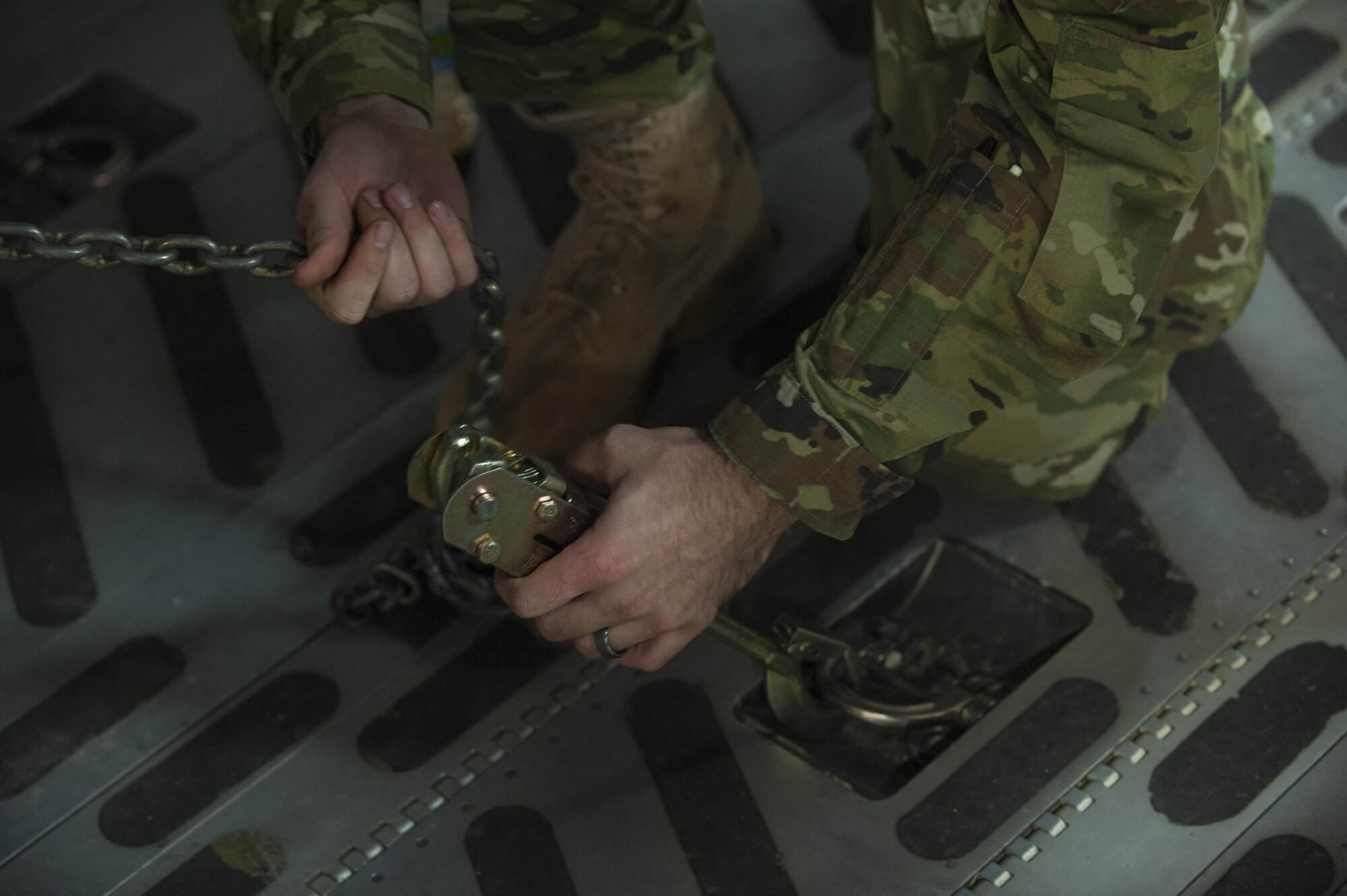 An Airman with the 33rd Helicopter Maintenance Unit secures an HH-60 Pave Hawk to the deck of a C-17 Globemaster III, Jan. 26, 2016, at Kadena Air Base. The HH-60 is capable of performing civil search and rescue, emergency aeromedical evacuation, disaster relief and international aid. (U.S. Air Force photo by Airman 1st Class Nick Emerick/Released)