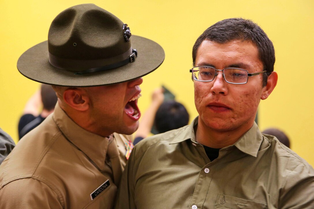 Marine Corps Staff Sgt. Joshua M. Cardona, left, instructs a new recruit to respond louder at Marine Corps Recruit Depot San Diego, Feb. 1, 2016. Recruits must respond to everything a drill instructor says to develop instant obedience to orders. Cardona is a drill instructor assigned to Receiving Company, Support Battalion. U.S. Marine Corps photo by Sgt. Tyler Viglione