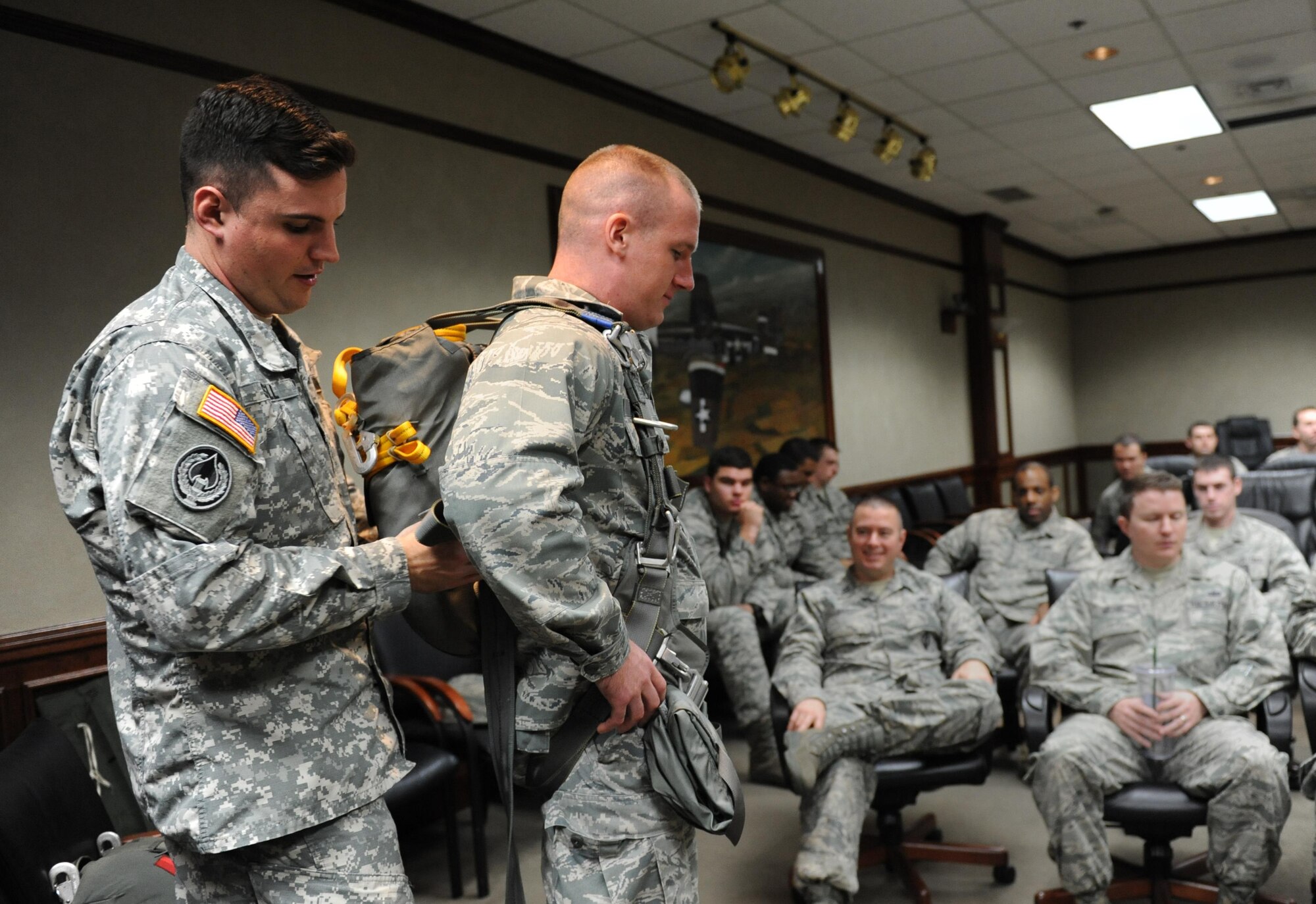 U.S. Army Capt. Eric Stell, Joint Communications Support Element troop commander, MacDill Air Force Base, Fla., secures a fully combat-equipped MC-6 parachute on 2nd Lt. Nicholas Arbour, 333rd Training Squadron undergraduate cyber student, during an equipment capabilities presentation at Stennis Hall Feb. 2, 2016, Keesler Air Force Base, Miss. Joint Communications Support Element provides rapidly deployable, scalable, en-route and early entry communications capabilities across the full spectrum of operations in order to enable rapid action of the joint force. (U.S. Air Force photo by Kemberly Groue)