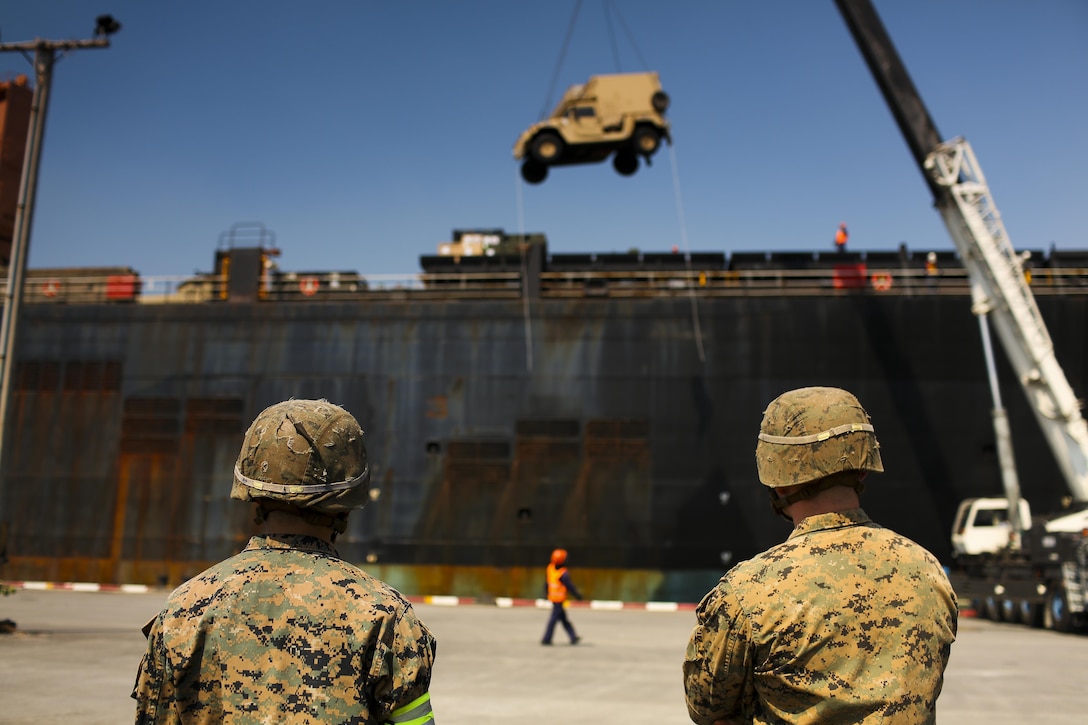 U.S. Marine Corps Cpl. Taylor White (left) and Lance Cpl. Scott Skith (right), both field artillery cannoneers, with 3rd Battalion, 12th Marines, wait for a vehicle to be offloaded from the USNS Maj. Stephen W. Pless, during exercise Cobra Gold 2016, on Sattahip Naval Base, Thailand, Jan. 28, 2016. Cobra Gold, in its 35th iteration, is an important element of the United States' and all other participating nations' regional military to military engagement efforts.
