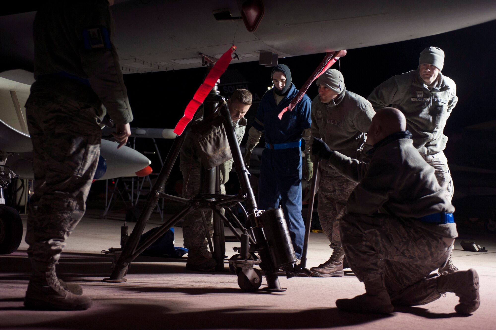 Airmen assigned to the 169th Aircraft Maintenance Squadron at McEntire Joint National Guard Base, S.C., safely lift an F-16 Fighting Falcon during Red Flag 16-1 on the flightline at Nellis Air Force Base, Nev., Feb. 2, 2016. To perform the final check of the inspection, the aircraft must be lifted off the ground. (U.S. Air Force photo by Senior Airman Mikaley Kline) 