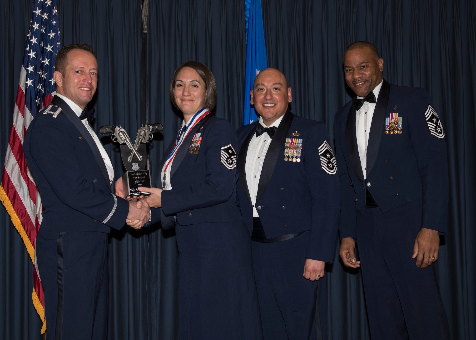 Master Sgt. Kathleen May accepts the 366th Fighter Wing First Sergeant of the Year award from 366th FW Commander Col. David Iverson, (left) 12th Air Force Command Chief Master Sgt. Jose Barraza and (right) 366th FW Command Chief Master Sgt. David Brown, during the Annual Awards Ceremony at Mountain Home AFB, Idaho, Jan. 29, 2016. May is a member of the 366th Operations Group at Mountain Home AFB. (U.S. Air Force photo by Senior Airman Jeremy L. Mosier/Released)