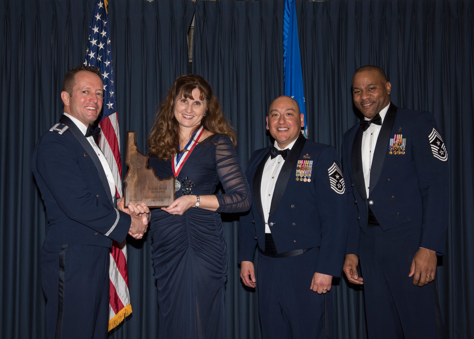 Stephanie Hudson accepts the 366th Fighter Wing Spouse Volunteer of the Year award from 366th FW Commander Col. David Iverson, (left) 12th Air Force Command Chief Master Sgt. Jose Barraza and (right) 366th FW Command Chief Master Sgt. David Brown, during the Annual Awards Ceremony at Mountain Home AFB, Idaho, Jan. 29, 2016. (U.S. Air Force photo by Senior Airman Jeremy L. Mosier/Released)