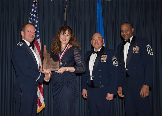 Stephanie Hudson accepts the 366th Fighter Wing Spouse Volunteer of the Year award from 366th FW Commander Col. David Iverson, (left) 12th Air Force Command Chief Master Sgt. Jose Barraza and (right) 366th FW Command Chief Master Sgt. David Brown, during the Annual Awards Ceremony at Mountain Home AFB, Idaho, Jan. 29, 2016. (U.S. Air Force photo by Senior Airman Jeremy L. Mosier/Released)
