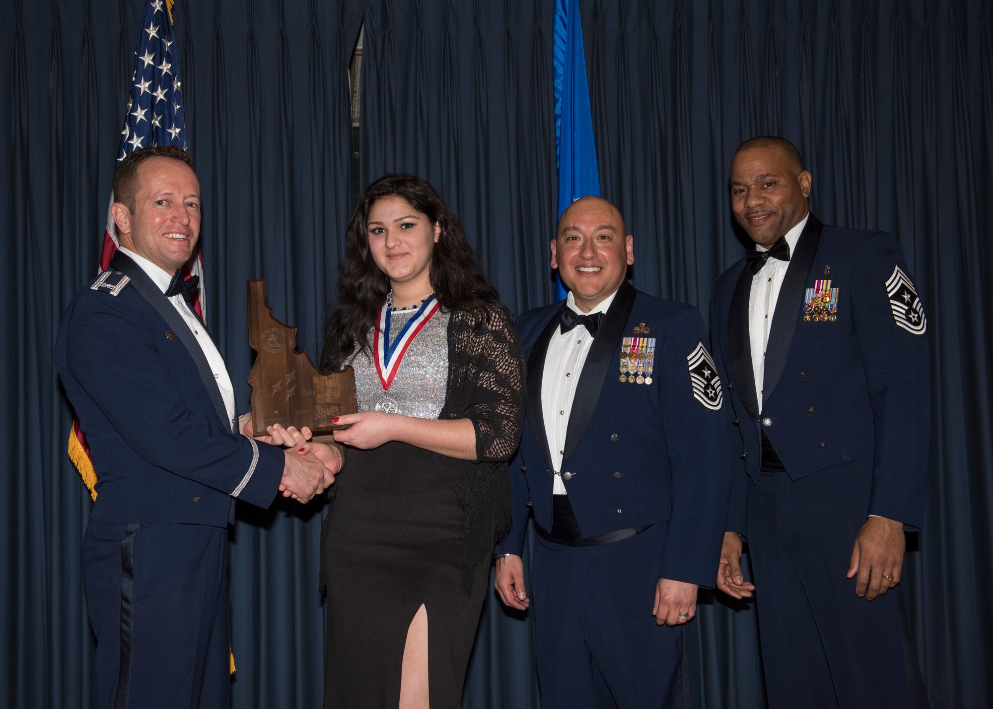 Destiny Campbell accepts the 366th Fighter Wing Junior Volunteer of the Year award from 366th FW Commander Col. David Iverson, (left) 12th Air Force Command Chief Master Sgt. Jose Barraza and (right) 366th FW Command Chief Master Sgt. David Brown, during the Annual Awards Ceremony at Mountain Home AFB, Idaho, Jan. 29, 2016. (U.S. Air Force photo by Senior Airman Jeremy L. Mosier/Released)