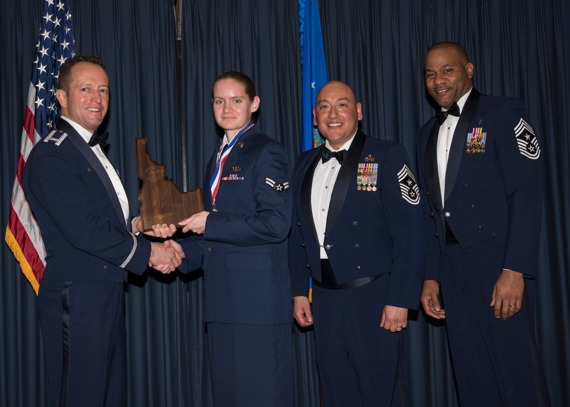 Airman 1st Class Jessica Kraus accepts the 366th Fighter Wing Active Duty Volunteer of the Year award from 366th FW Commander Col. David Iverson, (left) 12th Air Force Command Chief Master Sgt. Jose Barraza and (right) 366th FW Command Chief Master Sgt. David Brown, during the Annual Awards Ceremony at Mountain Home AFB, Idaho, Jan. 29, 2016. Kraus is a member of the 366th Mission Support Group at Mountain Home AFB. (U.S. Air Force photo by Senior Airman Jeremy L. Mosier/Released)
