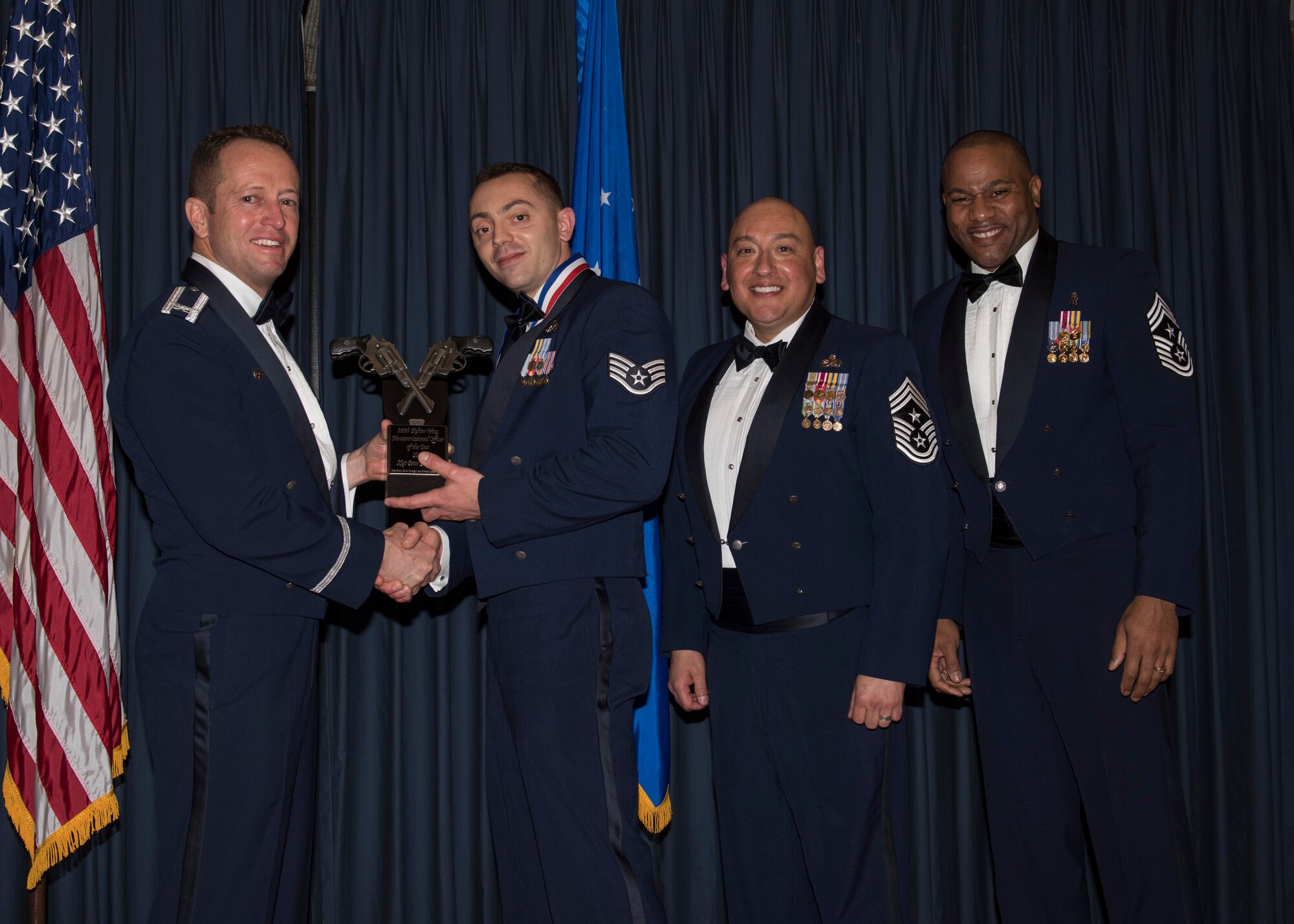 Staff Sgt. Peter Berger accepts the 366th Fighter Wing NCO of the Year award from 366th FW Commander Col. David Iverson, (left) 12th Air Force Command Chief Master Sgt. Jose Barraza and (right) 366th FW Command Chief Master Sgt. David Brown, during the Annual Awards Ceremony at Mountain Home AFB, Idaho, Jan. 29, 2016. Berger is a member of the 366th Mission Support Group at Mountain Home AFB. (U.S. Air Force photo by Senior Airman Jeremy L. Mosier/Released)