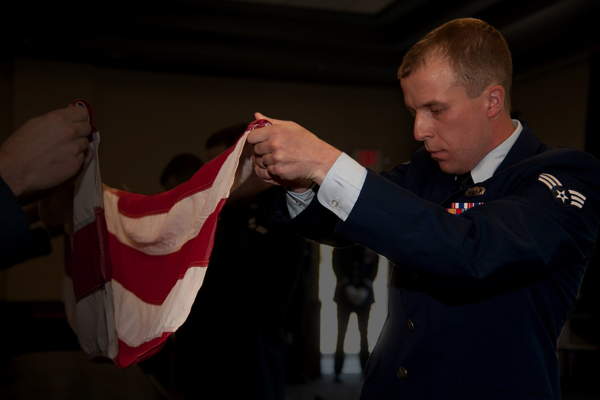 Senior Airman Sam Fogleman assumes the position of fold during his Honor Guard graduation ceremony, Sept. 11, 2015.  The two weeks of discipline training all comes together once you start performing real ceremonies. While performing funeral honors and colors presentations, the meaning of the whole assignment starts to come to light. The funeral honors, in particular, can make the most grizzled, jaded and hardened Airmen into relatively proud members of the greater military community. - Senior Airman Samuel Fogleman. (Courtesy Photo)
