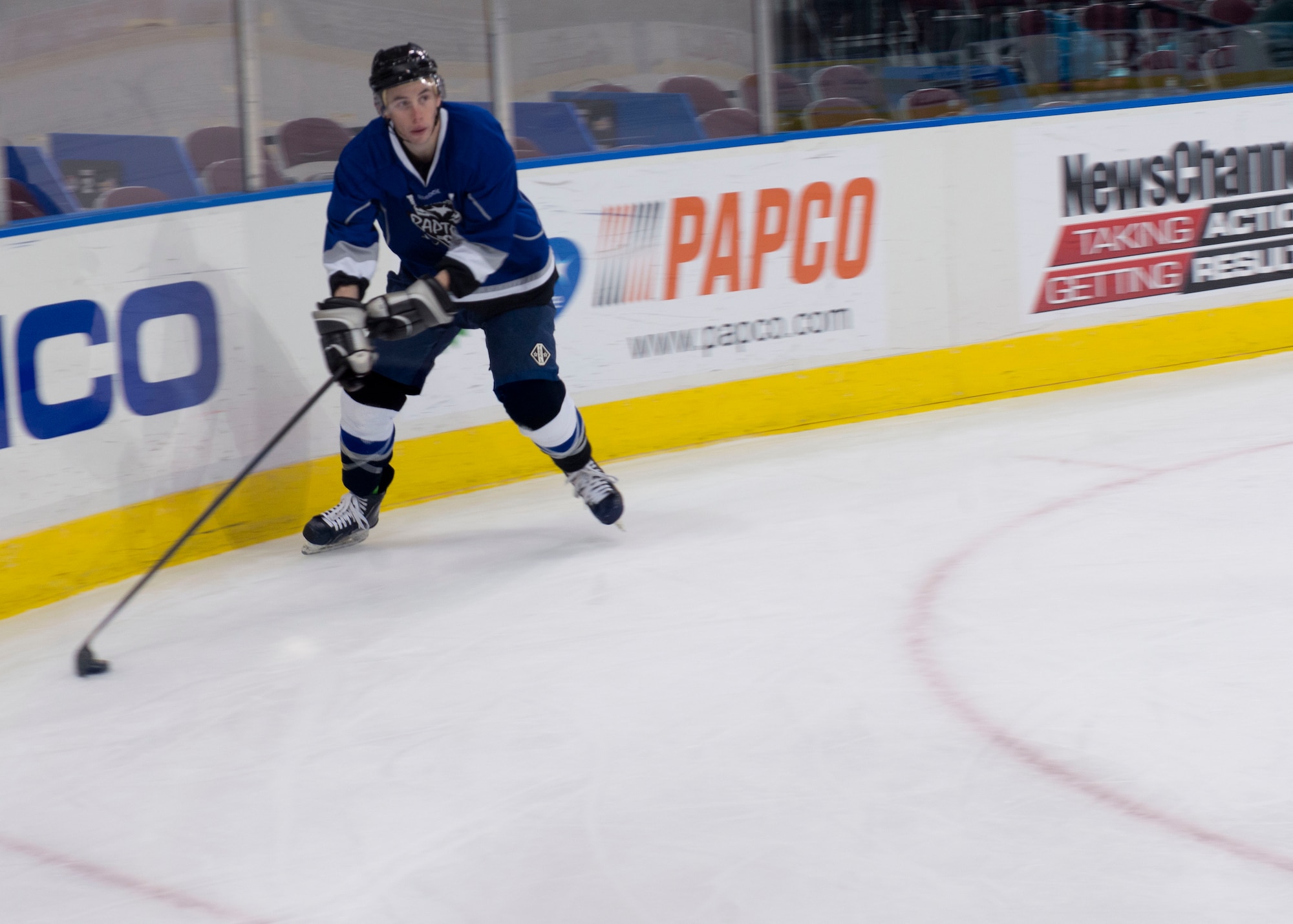 A member of the Langley Air Force Base Men’s Varsity Hockey team, the Langley Raptors, moves the puck towards the goal during the “Air versus Sea” hockey game at the Norfolk Scope Arena in Norfolk, Va., Jan. 30, 2016. The Raptors played in the inaugural hockey game against the U.S. Navy U.S.S. Abraham Lincoln CVN- 72. (U.S. Air Force photo by Staff Sgt. J.D. Strong II)