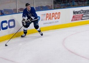 A member of the Langley Air Force Base Men’s Varsity Hockey team, the Langley Raptors, moves the puck towards the goal during the “Air versus Sea” hockey game at the Norfolk Scope Arena in Norfolk, Va., Jan. 30, 2016. The Raptors played in the inaugural hockey game against the U.S. Navy U.S.S. Abraham Lincoln CVN- 72. (U.S. Air Force photo by Staff Sgt. J.D. Strong II)