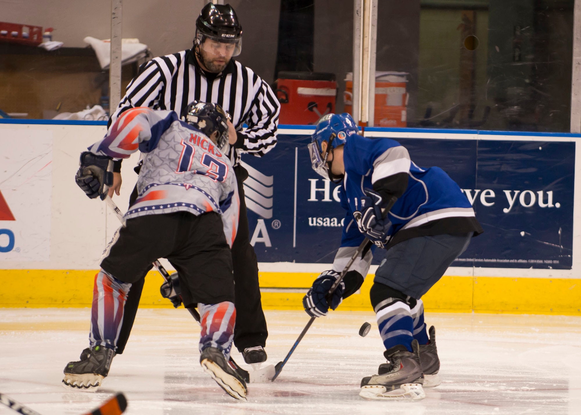 Members of the Langley Air Force Base and U.S. Navy U.S.S. Abraham Lincoln hockey teams’ face-off during the “Air versus Sea” hockey game at the Norfolk Scope Arena in Norfolk, Va., Jan. 30, 2016. The Raptors scored in the final minutes to up the score to 8 to 4. (U.S. Air Force photo by Staff Sgt. J.D. Strong II)