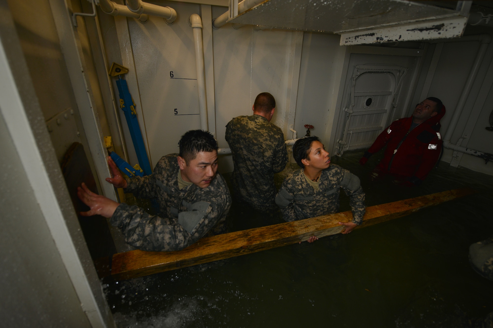 U.S. Army Pvt. Joseph McDermott, a student assigned to the Maritime Intermodal Training Department watercraft operator course, attempts to stop water from bursting out of a pipe during a simulation exercise at Fort Eustis, Va., Jan. 26, 2016. The students worked as an assembly to gather various materials used to stop water from sinking the training tank.  (U.S. Air Force photo by Staff Sgt. Natasha Stannard)