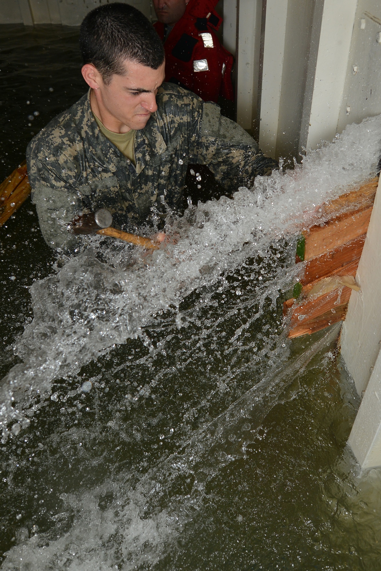 U.S. Army Pvt. Brent Bates, a student assigned to the Maritime Intermodal Training Department watercraft operator course, hammers wedges into a rupture during a simulation exercise at Fort Eustis, Va., Jan. 26, 2016.  The wedges were used to stop water from bursting through the ruptures during the damage control tank simulator training. .  (U.S. Air Force photo by Staff Sgt. Natasha Stannard)