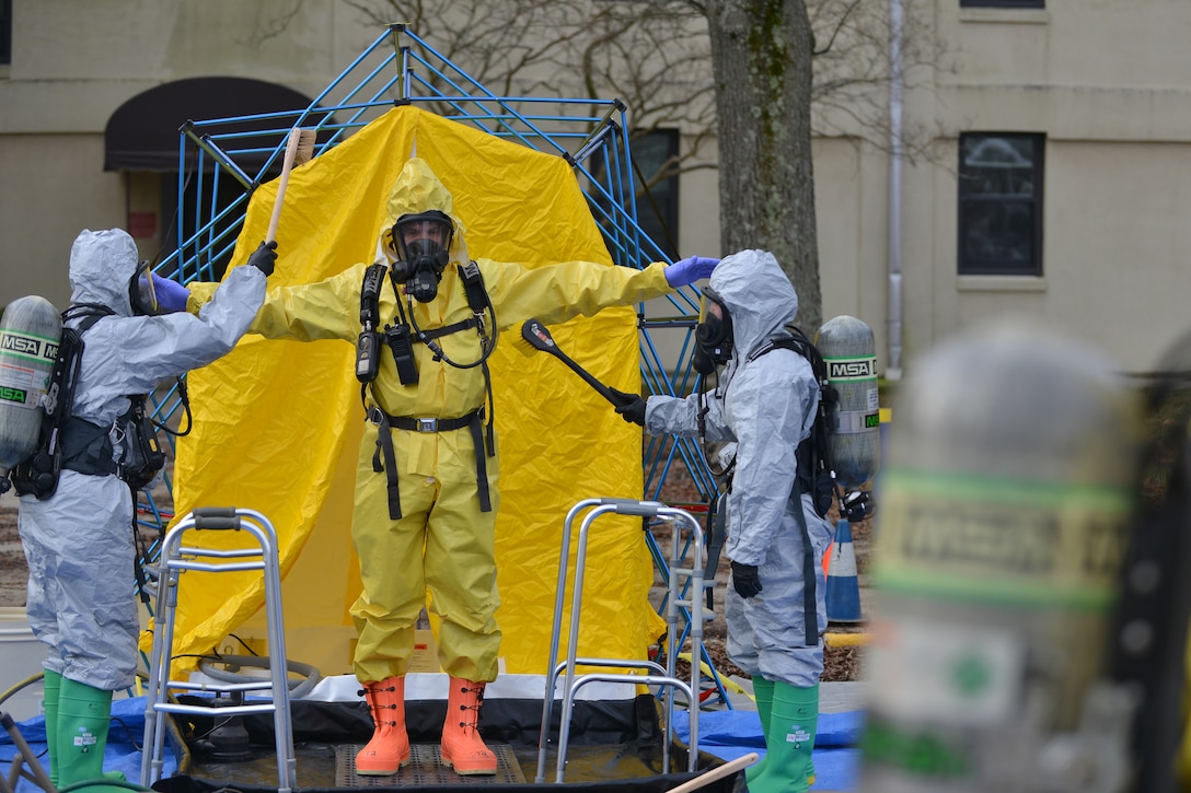 U.S. Airmen simulate cleaning chemical, biological, radiological, nuclear and high-yield explosive (CBRNE) threats off a firefighter after he entered a CBRNE training area at Fort Eustis, Va., Jan. 28, 2016. After exposure to CBRNE materials, personnel must clean their protective gear to prevent the risk of exposure spreading beyond the affected area. (U.S. Air Force photo by Staff Sgt. Natasha Stannard)