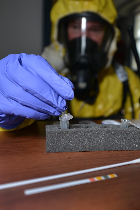A firefighter tests the PH-levels of an unknown substance to determine its threat during a joint chemical, biological, radiological, nuclear and high-yield explosive (CBRNE) threat exercise at Fort Eustis, Va., Jan. 28, 2016. The firefighters donned CBRNE protective gear to simulate real-world procedures that protect them from the dangers of CBRNE materials. (U.S. Air Force photo by Staff Sgt. Natasha Stannard)