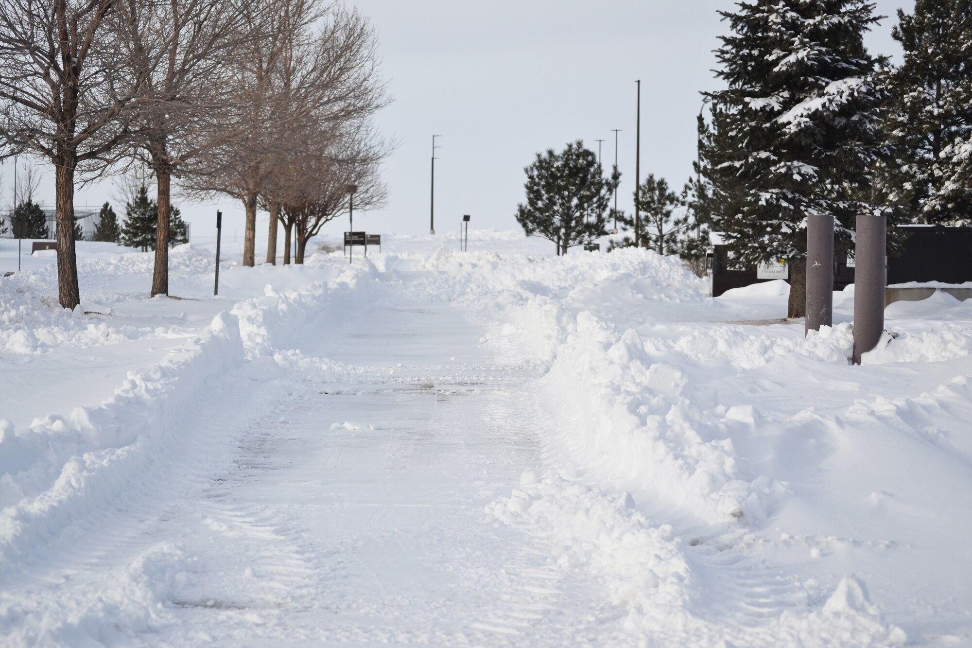 The freshly plowed sidewalk outside of Building 210 at Schriever Air Force Base, Colorado stands ready to welcome foot traffic again Tuesday, Feb. 2, 2016. A massive winter storm dumped several inches of snow throughout the area causing base closures Monday and Tuesday. The 50th Civil Engineer Squadron snow removal team worked non-stop to ensure clear and safe roadways on base throughout the weekend. (U.S. Air Force photo/Brian Hagberg) 