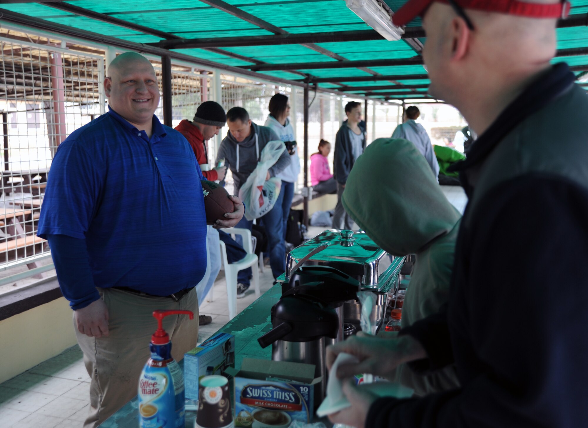 Tom Graham, 39th Force Support Squadron Outdoor Recreation director, speaks with Col. Mark Anarumo, 39th Air Base Wing vice commander, while he receives hot coco before the polar plunge event held at the base pool Jan. 30, 2016, at Incirlik Air Base, Turkey. This year marks the fourth annual polar plunge. (U.S. Air Force photo by Airman 1st Class Daniel Lile/Released)