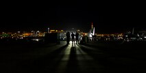 Four Airmen stand on the flightline looking toward the lights of Las Vegas Jan. 26, at Nellis AFB, Nev. The Airmen are part of more than 3,000 personnel from over 30 units including squadrons from Australia and the United Kingdom here to participate in Red Flag 16-1. (U.S. Air Force photo by Senior Airman Alex Fox Echols III/Released)  