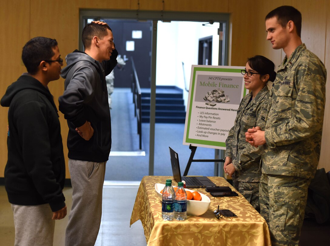 Airman 1st Class Diego Rojas-Rodriguez, 341st Civil Engineer Squadron electrical systems apprentice, far left, and Airman 1st Class Rolando Rodriquez, 341st CES electrical systems apprentice, left, speak to members of the Malmstrom Air Force Base mobile finance team after a physical training session at the Malmstrom Fitness Center Jan. 29, 2016. Currently, the mobile finance team is in its test phase and is aiming to offer services at the Malmstrom Fitness Center, Building 500 and the 819th RED HORSE squadron to start. (U.S. Air Force photo/Airman Collin Schmidt) 