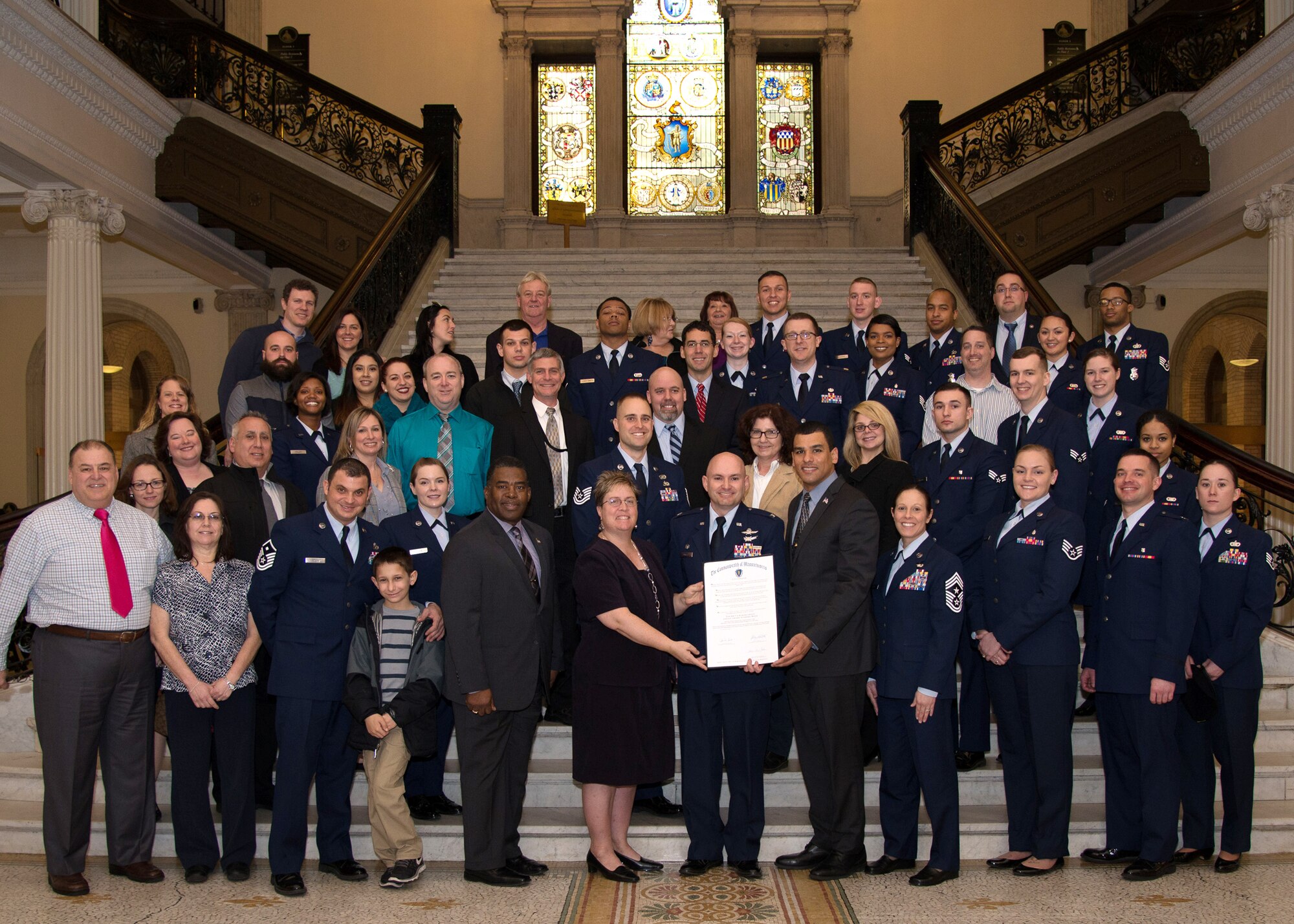 Col. David R. Dunklee, front row center, 66th Air Base Group commander, is presented a proclamation by Massachusetts Department of Veterans’ Services Secretary Francisco Urena during a visit to the Mass. State House Feb. 1. As part of the visit to the State House, 66 ABG annual award nominees and their guests were provided a tour of the commonwealth’s capital building built in 1798. (U.S. Air Force photo by Mark Herlihy)