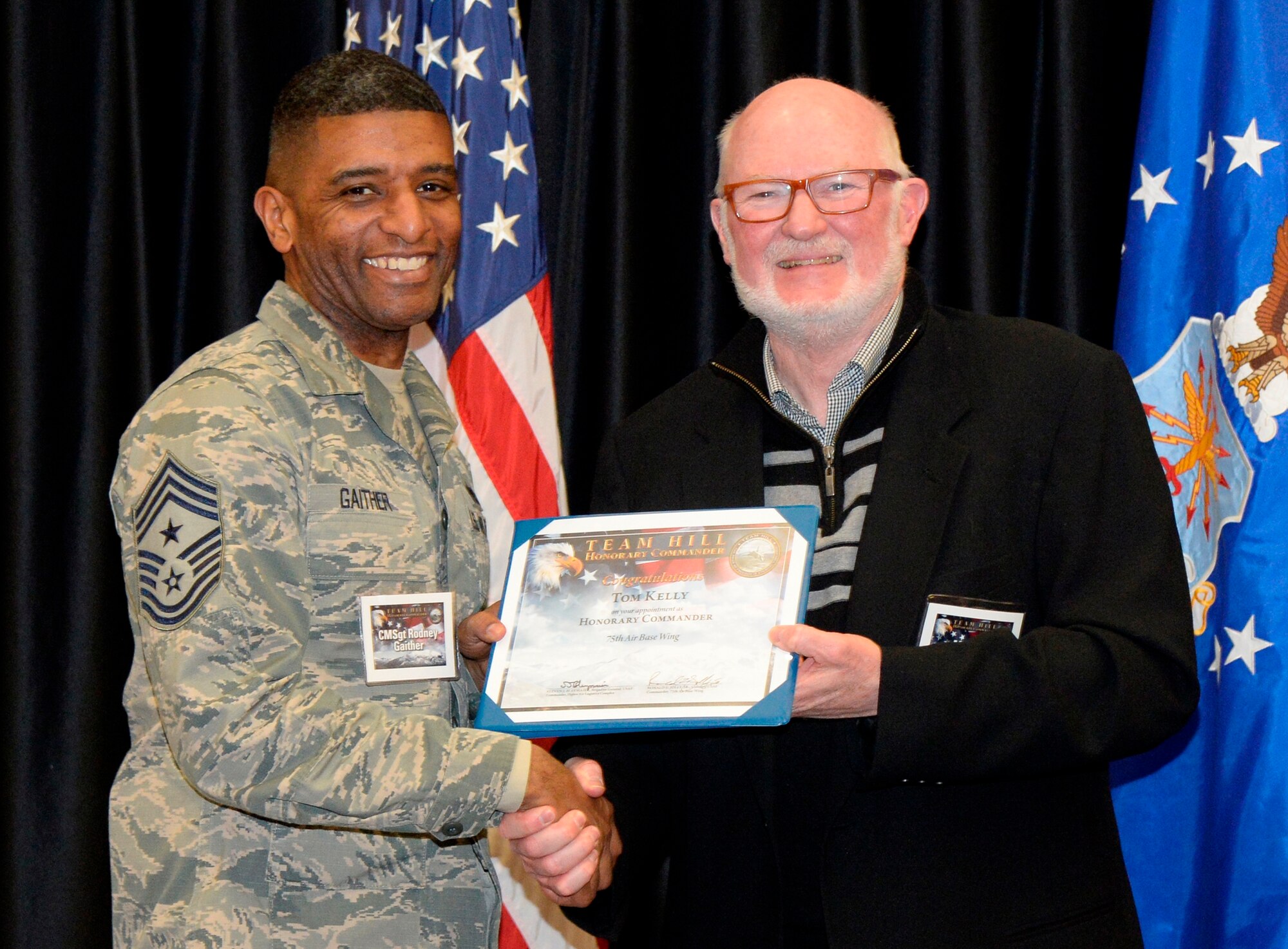Chief Master Sgt. Rodney Gaither (left), 75th Air Base Wing command chief, welcomes honorary Tom Kelly, U.S. Ski & Snowboard Association, into the organization. Twenty-eight community members and business leaders were appointed to the Honorary Commander Program during an induction ceremony at Hill Air Force Base Feb. 3. (U.S. Air Force photo by Todd Cromar)
