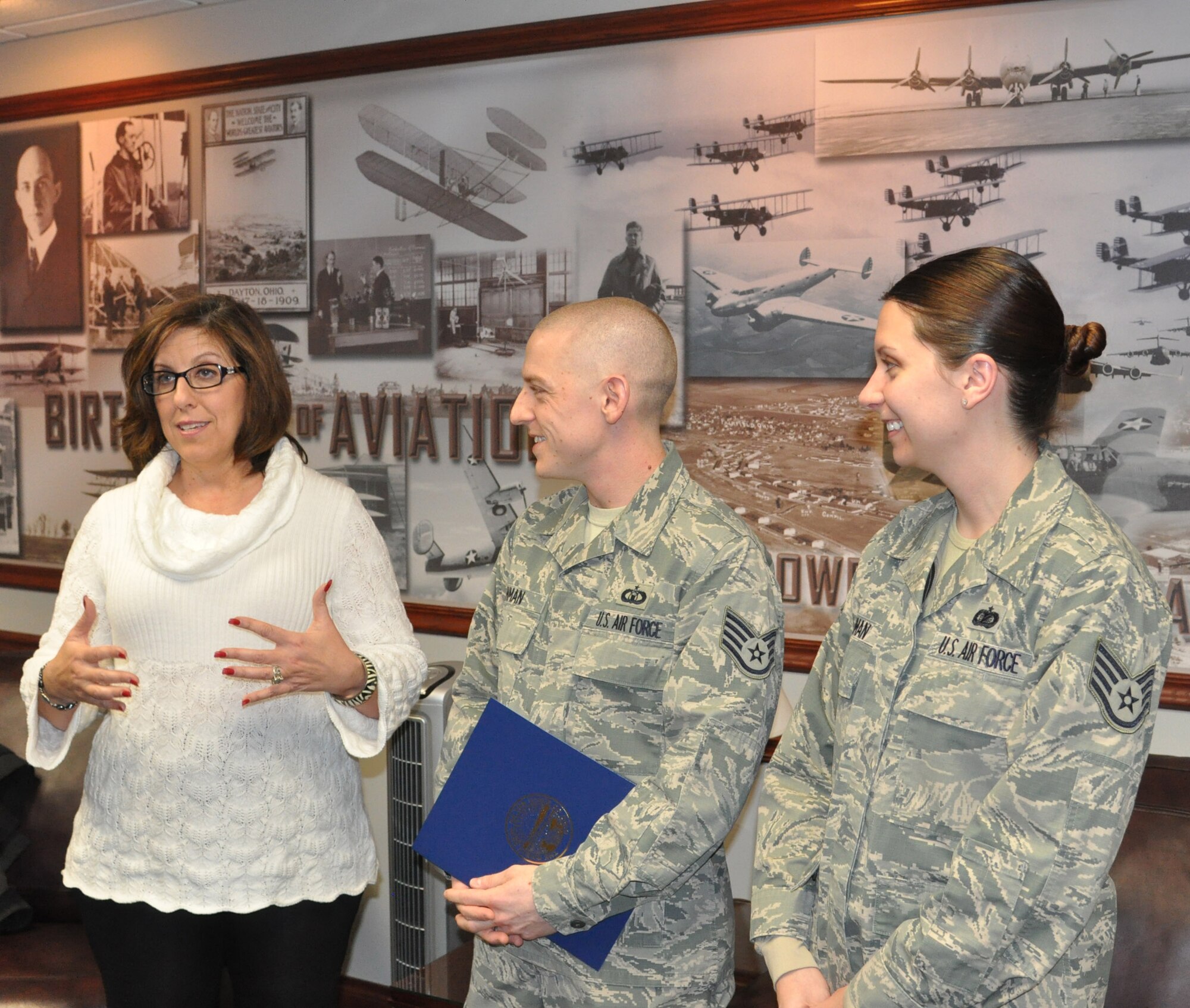 Sandra Brasington, Western Ohio Regional Liaison for Ohio Governor John R. Kasich, makes remarks about the Miami Valley Military Affairs Association’s Outstanding Military Member Award during her presentation of the award to Staff Sgt. Bryan Inman while accompanied by his spouse, Staff Sgt. Aimee Inman. (U.S. Air Force photo/Bryan Ripple.)