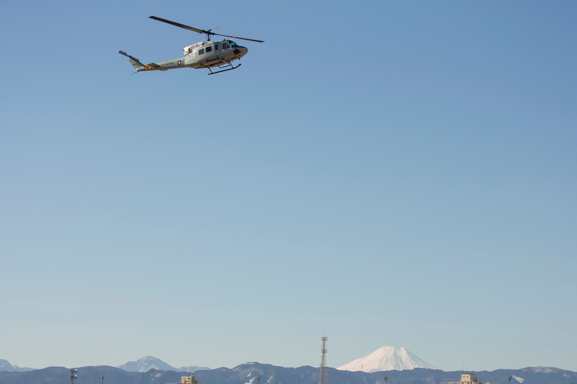 A UH-1N Iroquois with the 459th Airlift Squadron flies over Yokota Air Base, Japan, during a routine sortie Jan. 25, 2016. UH-1Ns are primarily used at Yokota for humanitarian support, distinguished visitor missions, bilateral training missions, and search and rescue capabilities. (U.S. Air Force photo by Osakabe Yasuo/Released)