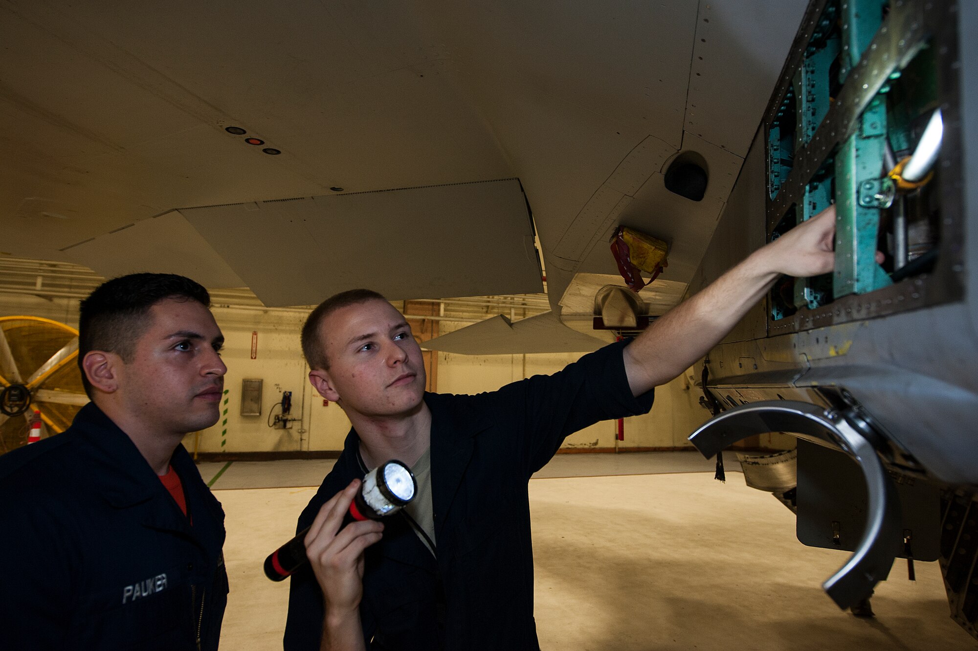 U.S. Air Force Airmen 1st Class Jorge Pauker and Zackary Maes, 18th Equipment Maintenance Squadron inspection section team member, inspect an F-15 Eagle Jan. 29, 2016, at Kadena Air base, Japan.  Airmen crew chiefs are responsible for ensuring every part of the jet is in safe, working order. (U.S. Air Force photo by Airman 1st Class Corey M. Pettis)