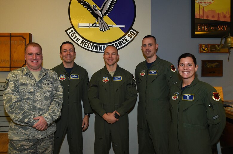 Tech. Sgt. Leonel, 15th Reconnaissance Squadron instructor sensor operator, center, poses with his leadership for a photo Jan. 29, 2015, at Creech Air Force Base, Nevada. Leonel was promoted under the Stripes for Exceptional Performers program as a testimony to his character as an Airman. (U.S. Air Force Photo by Airman 1st Class Kristan Campbell/Released)