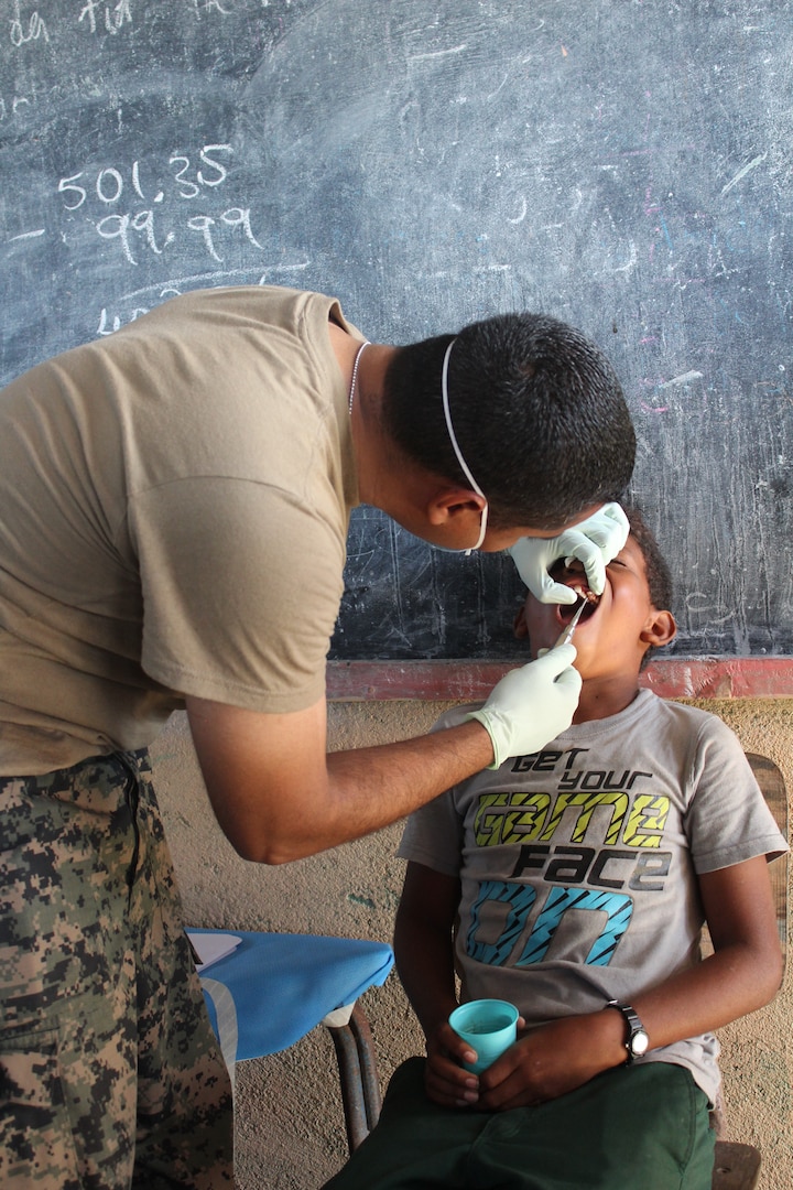 A Honduran soldier performs a tooth extraction from a child during a Medical Readiness Training Exercise between U.S. Service members from Joint Task Force-Bravo and Honduran participants, in Nueva Jerusalén, Gracias a Dios Department, Honduras, Jan. 28, 2016.  These partnerships allow service members to engage with the local community, while supporting local military and local health organizations in remote areas of the country. (U.S. Army photo by Maria Pinel/Released)
