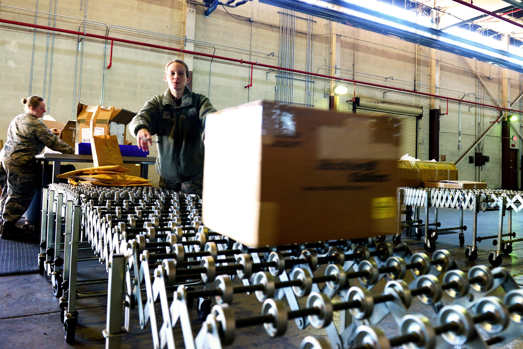 Senior Airman Joanna Barnette, 2nd Logistics Readiness Squadron traffic management journeyman, slides a package down the processing line for shipment at Barksdale Air Force Base, La., Jan. 29, 2016. Traffic management flight helps Barksdale's mission by delivering personal property as well as mission-essential items. (U.S. Air Force photo/Airman 1st Class Luke Hill)

