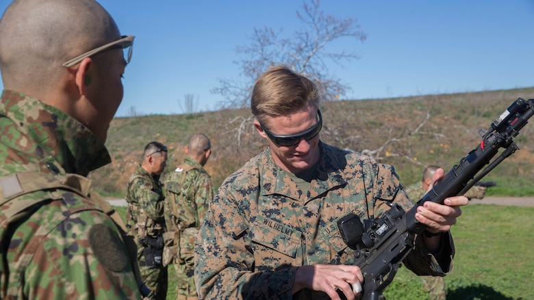 Sergeant 1st Class Yusuke Irie of the Japan Ground Self-Defense Force, Western Army Infantry Regiment watches as U. S. Marine Corps Sgt. Mason Wilhelmy, a scout sniper instructor with 1st Marine Division Schools, gets a hands-on review of the JGSDF weapons during an abbreviated scout sniper course held during Exercise Iron Fist 2016, on Marine Corps Base Camp Pendleton, Calif., Feb. 1, 2016. The course offers the U.S. Marines and JGSDF soldiers the opportunity to share their experiences and knowledge and increase camaraderie between the Marine Corps and JGSDF in a bilateral training environment. 