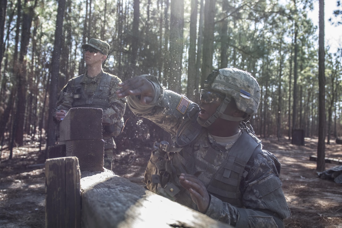 Army Drill Sergeant, Staff Sergeant Jonathan Martin, C Company, 1st Battalion, 61st Infantry Regiment watches as a Solider in basic combat training tosses a practice grenade from the kneeling position on the hand grenade assault course at Fort Jackson, S.C., Feb. 1, 2016. (U.S. Army photo by Sgt. 1st Class Brian Hamilton)