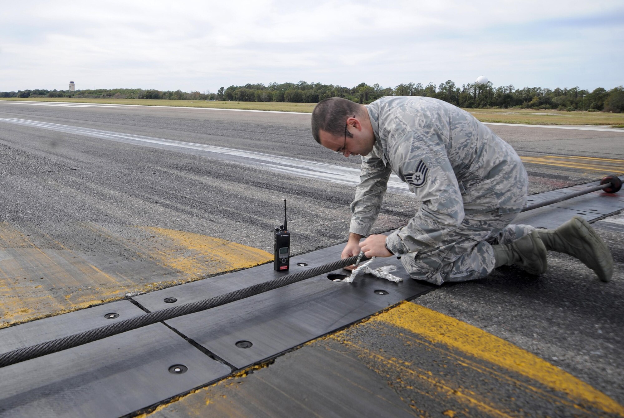 Staff Sgt. Michael David, an airfield management operations supervisor with the 6th Operations Support Squadron, removes a loose rope found on the flightline during a routine check at MacDill Air Force Base, Fla., Jan. 22, 2016. Airfield management Airmen must stay vigilant in order to detect a wide variety of safety hazards. (U.S. Air Force photo/Airman 1st Class Mariette M. Adams)