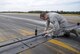 Staff Sgt. Michael David, an airfield management operations supervisor with the 6th Operations Support Squadron, removes a loose rope found on the flightline during a routine check at MacDill Air Force Base, Fla., Jan. 22, 2016. Airfield management Airmen must stay vigilant in order to detect a wide variety of safety hazards. (U.S. Air Force photo/Airman 1st Class Mariette M. Adams)