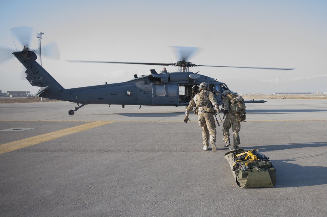 Air Force pararescuemen drag gear to an HH-60 Pave Hawk helicopter waiting at an extraction point during an extrication exercise on Bagram Airfield, Afghanistan, Jan. 23, 2016. Air Force photo by Tech. Sgt. Robert Cloys