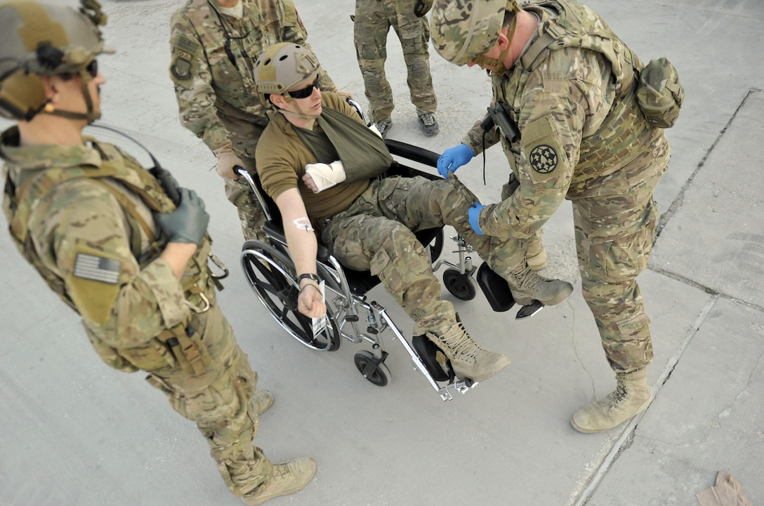 Army Master Sgt. Brian Breaker, right, checks a simulated patient for contraband before wheeling him into the trauma bay at Craig Joint Theater Hospital on Bagram Airfield, Afghanistan Jan. 23, 2016. Air Force photo by Capt. Bryan Bouchard