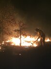 An Airman assigned to the 7th Civil Engineer Squadron Fire Department works the line during a 750-acre wildfire near the community of Eula, Texas, on the evening of Jan. 30, 2016. Seven Dyess firefighters along with their firefighting equipment and trucks were called to support a collaboration of 15 state, county and city officials as part of a mutual aid agreement Dyess Air Force Base has with the local community. (U.S. Air Force photo by Floyd Jones/Released)

