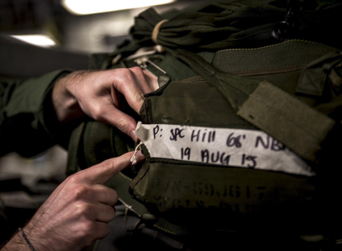 Air Force Staff Sgt. Kyle Mace inspects a container delivery system bundle on Pope Army Airfield, N.C., Feb. 3, 2016. Air Force photo by Staff Sgt. Marianique Santos