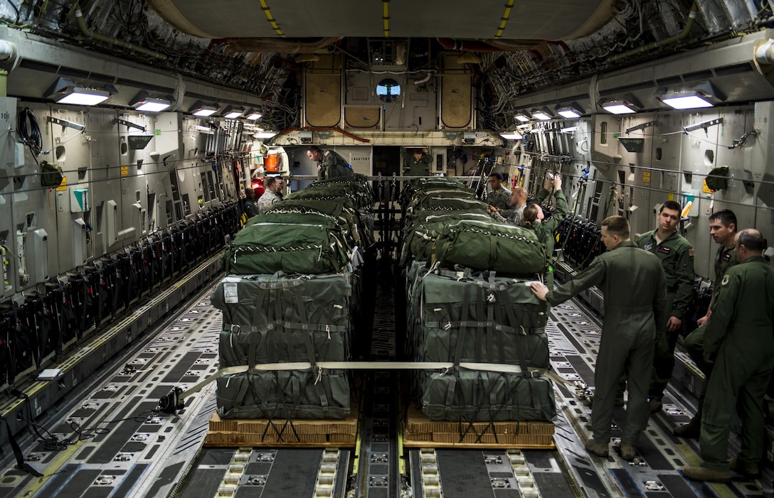 Air Force loadmasters, joint airdrop inspectors and Army parachute riggers inspect and prepare container delivery system bundles for transport and airdrop on Pope Army Airfield, N.C., Feb. 3, 2016. Air Force photo by Staff Sgt. Marianique Santos