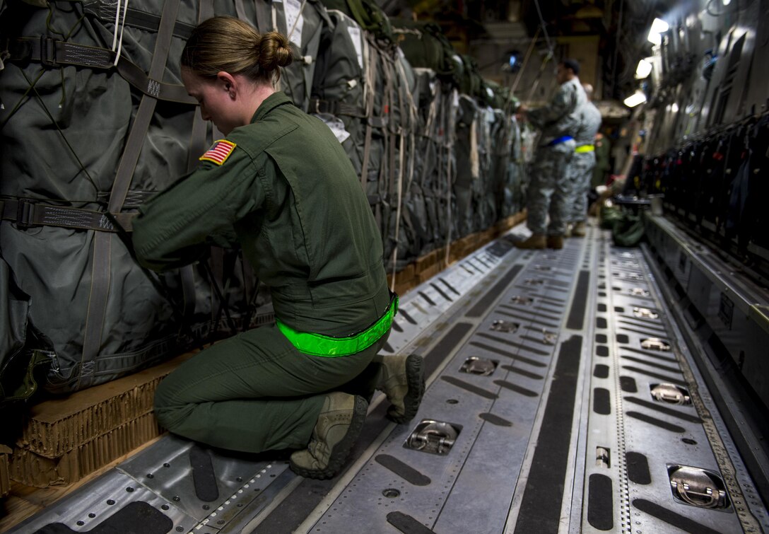 Air Force Staff Sgt. Brittany Canzoneri tightens a knot on a container delivery system bundle Pope Army Airfield, N.C., Feb. 3, 2016. Canzoneri is a loadmaster and joint airdrop inspector assigned to the 43rd Operations Support Squadron. Air Force photo by Staff Sgt. Marianique Santos