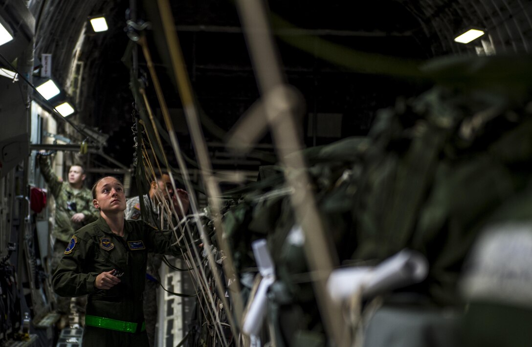 Air Force Staff Sgt. Brittany Canzoneri inspects static lines connected to container delivery system bundles on Pope Army Airfield, N.C., Feb. 3, 2016. Air Force photo by Staff Sgt. Marianique Santos