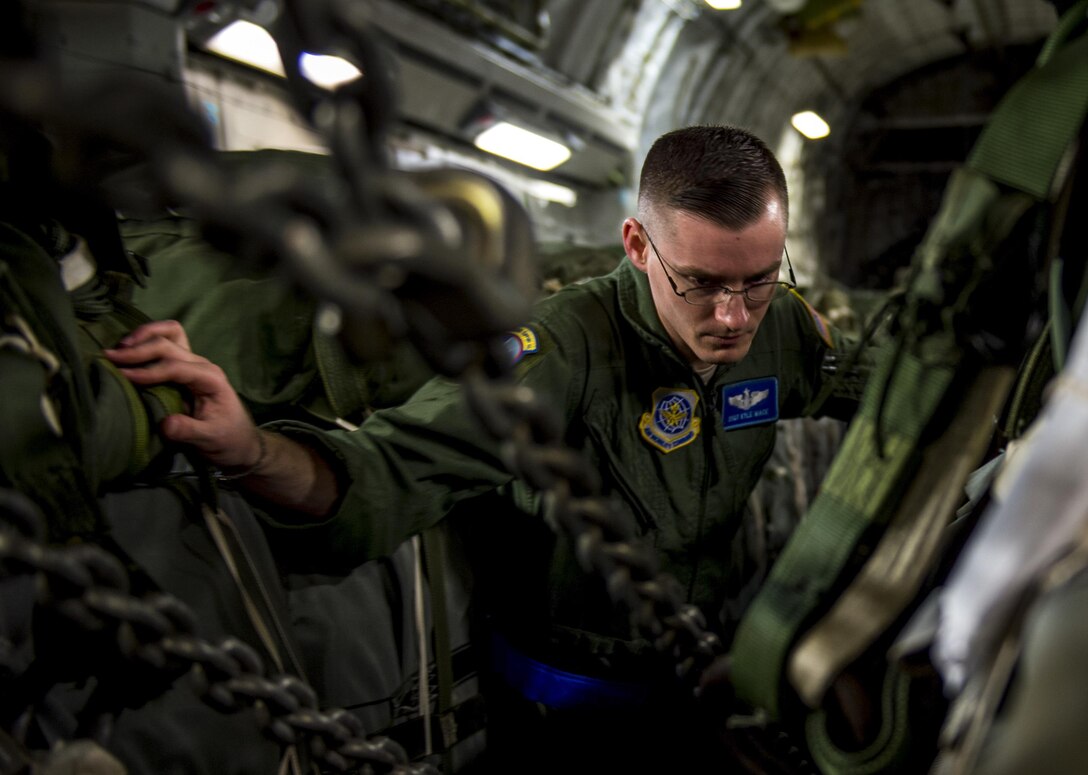 Air Force Staff Sgt. Kyle Mace conducts final checks on container delivery system bundles on a C-17 Globemaster III aircraft on Pope Army Airfield, N.C., Feb. 3, 2016. Mace is a loadmaster and joint airdrop inspector assigned to the 437th Operations Support Squadron. Air Force photo by Staff Sgt. Marianique Santos