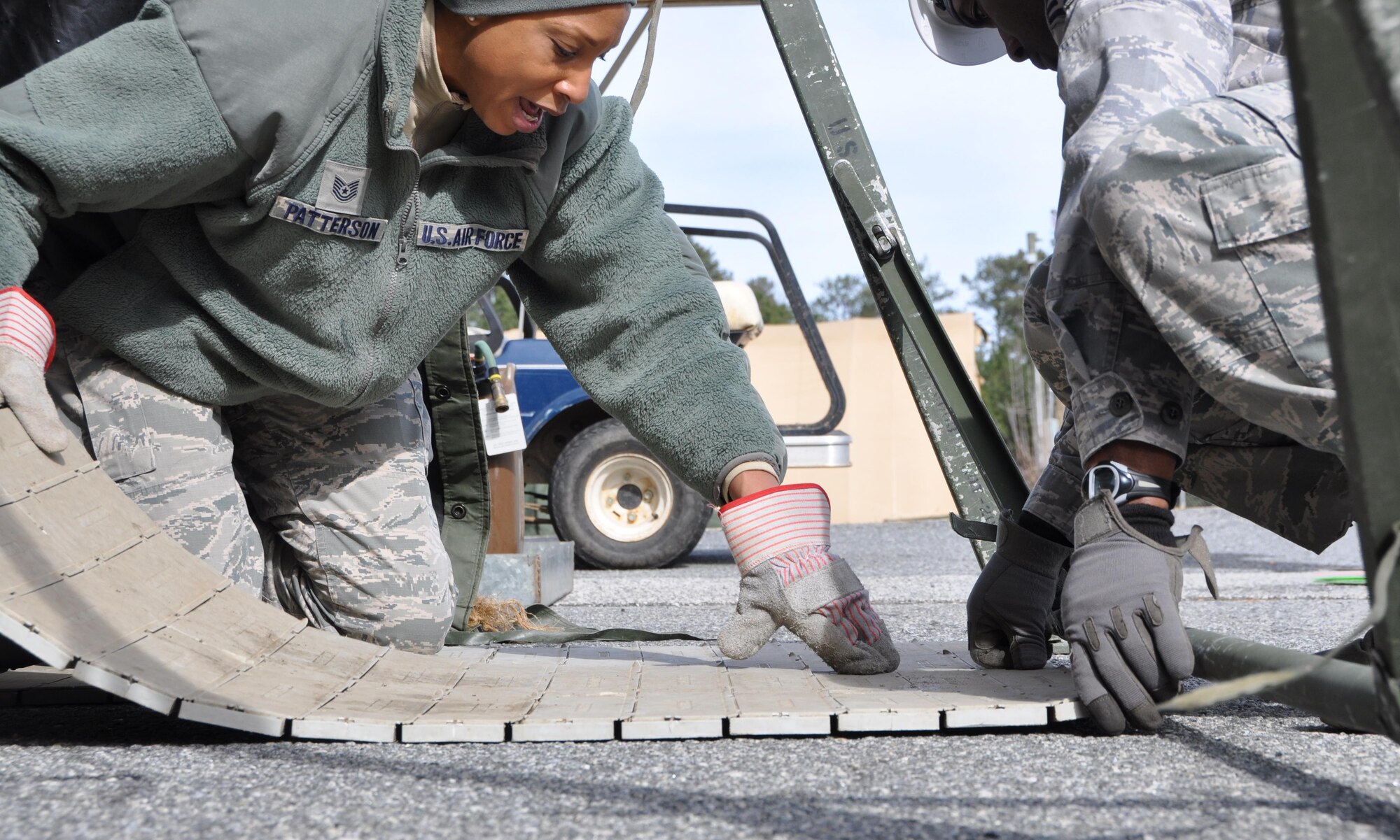 Technical Sgt. Latoya Patterson, 622nd Civil Engineer Group Force Support Silver Flag training instructor, shows training Airmen how to lay flooring for the food service tent in a deployed environment Jan. 25, 2016 at Dobbins Air Reserve Base, Ga. Patterson gave students hands-on, real-world demonstrations of tent structures and equipment in the FSSF field training facility. (Photo by U.S. Air Force Senior Airman Lauren Douglas)