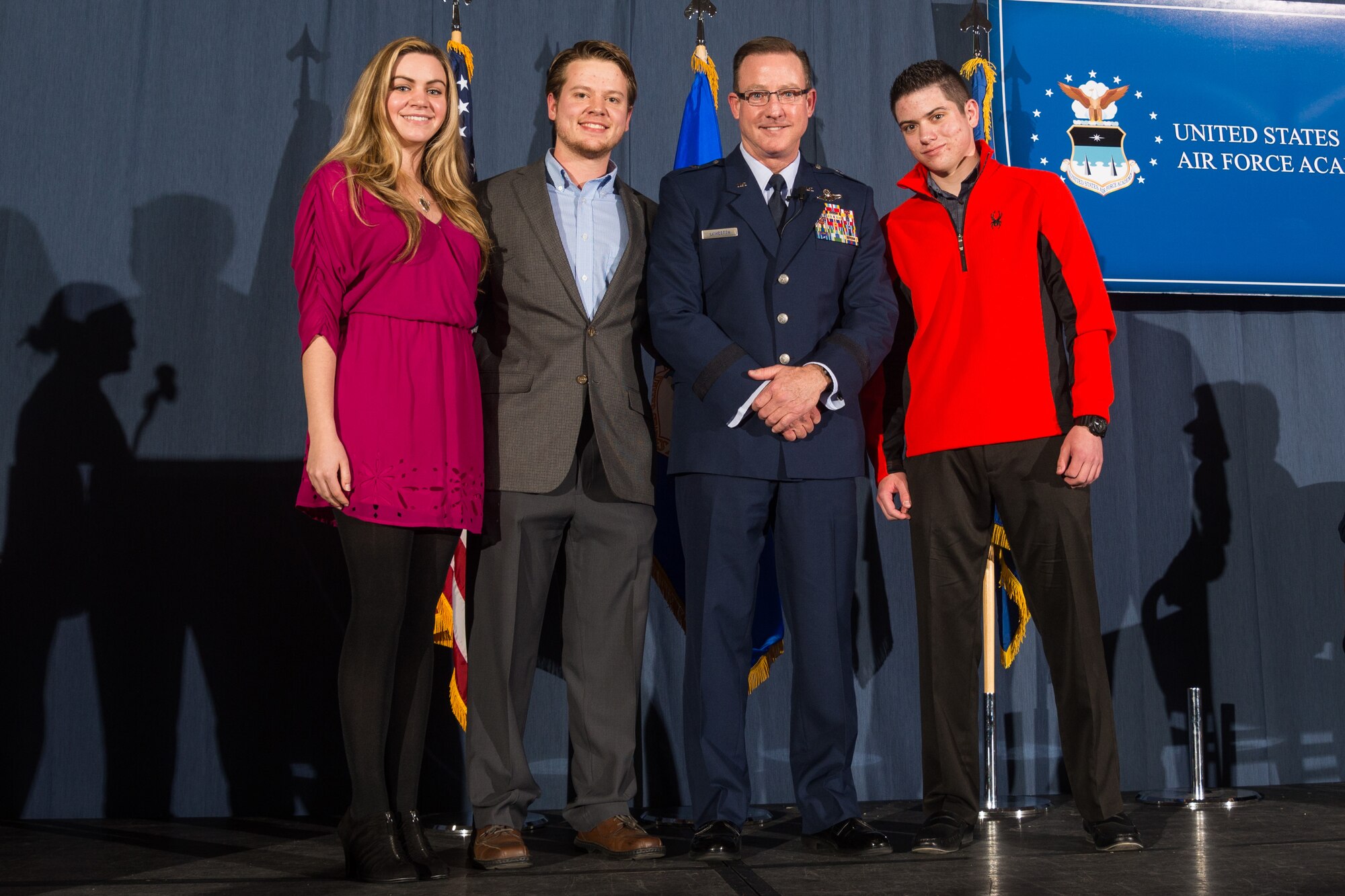 Brig. Gen. Kevin Lamberth, the vice superintendent of the U.S. Air Force Academy, stands on stage with daughter-in-law Katelyn (left) and sons Austin and Nathan Lambert (right) during his promotion ceremony, Jan. 29, 2016 at the Falcon Club.  Lamberth was officially promoted to brigadier general Jan.1, 2016, but scheduled the ceremony later in the month so relatives and friends could attend. (U.S. Air Force photo/Liz Copan)
