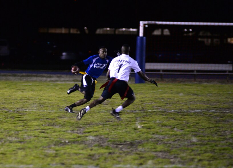 A 2nd Maintenance Squadron flag football running back sprints to avoid a defender during a playoff semifinals game at Barksdale Air Force Base, La., Jan. 27, 2016. The flag football regular season concluded after three months of action in which each team played 10 games. The top eight teams made the post season in an eight-team single-elimination playoff. (U.S. Air Force photo/Airman 1st Class Curt Beach)