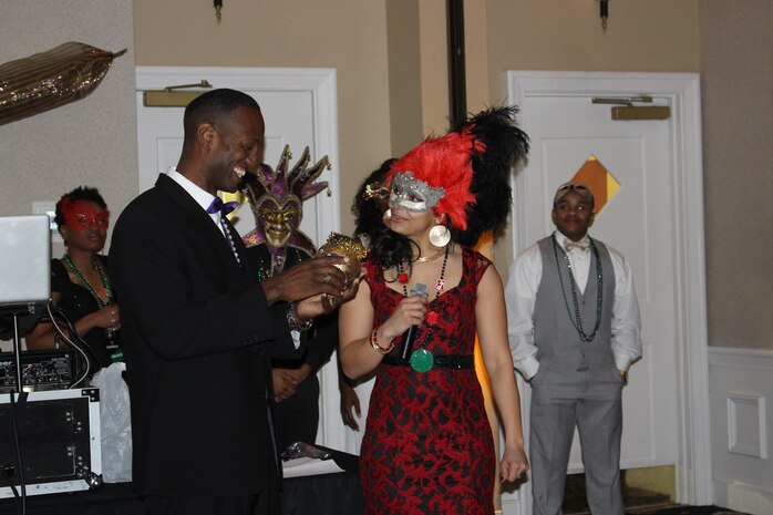 Sgt. Elaine Deloney, Manpower Management Officer Assignments, presents a gilded coconut as a thank-you gift to the ball’s guest of honor, Master Sgt. Aaron Bonner, Manpower Management Enlisted Assignments.