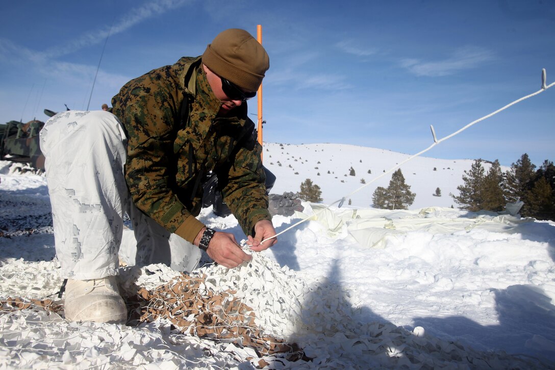 Cpl. Robert Schmitt sews an artic camouflage net during cold weather training at Marine Corps Mountain Warfare Training Center, Calif., Jan. 21, 2016. The cold weather training done in the Sierra Mountains is a warm-up to Exercise Cold Response 1-16 in Norway. Nearly 80 Marines with 2nd LAAD Bn. participated in the two-weeklong exercise that taught basic mobility in snow, defensive and offensive tactics as well as basic cold weather and high altitude conditions training.