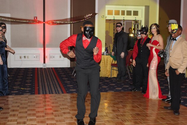 The Headquarters and Service Battalion Masquerade Ball began with a parade in which couples and individuals showed off their costumes. Here, PFC Jeremery D. Webb dances down the aisle.