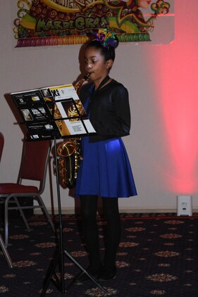 Ayianna, 11, the daughter of Mardi Gras Masquerade Ball guest of honor Master Sgt. Aaron Bonner, performs “When the Saints Go Marching In” on her saxophone at the ball on Jan. 29.